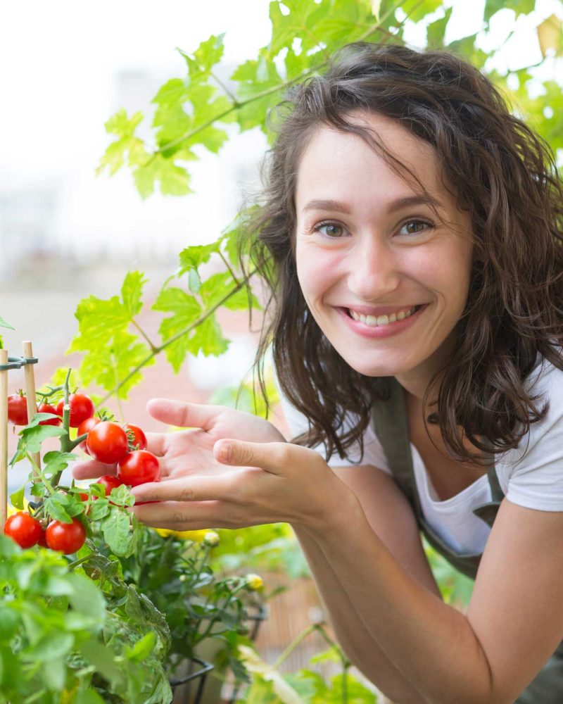 Frau freut sich über Balkontomaten